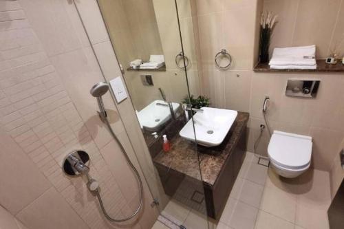 a bathroom with a shower and a toilet and a sink at one bedroom Modern Apartment Muscat Bay in Muscat