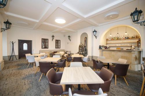 a restaurant with tables and chairs and a bar at Hotel Praha in Špindlerův Mlýn