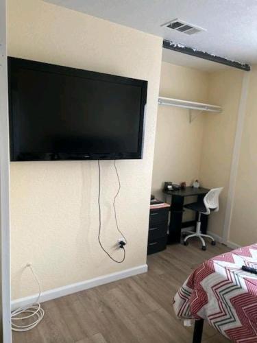 a room with a large flat screen tv on the wall at Be Our Guest-Shared Home Tampa in Palmdale