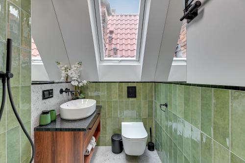 a bathroom with a sink and a toilet and a window at Downtown Apartments Old Town Świętojańska in Gdańsk