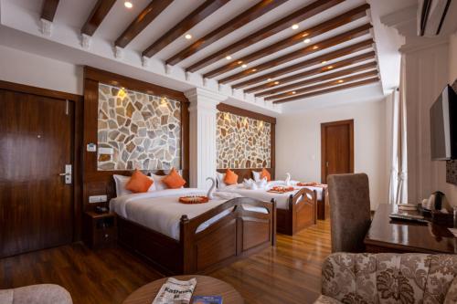 a bedroom with two beds and a living room at Airport Himalaya Boutique Hotel in Kathmandu