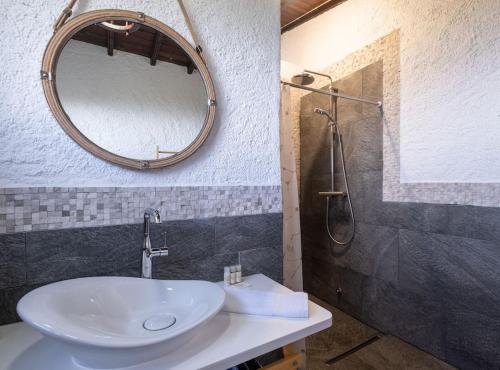 La salle de bains est pourvue d'un lavabo, d'un miroir et d'une douche. dans l'établissement Ocean View - Nordeste, à Feteira Grande