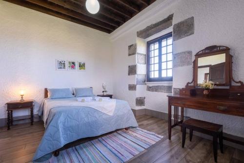 sypialnia z łóżkiem, komodą i lustrem w obiekcie Ocean View - Nordeste w mieście Feteira Grande