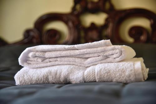 a pile of towels sitting on top of a bed at stazione trastevere公寓 in Rome