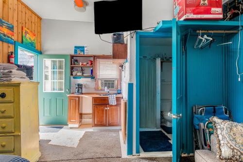 cocina con paredes azules y puerta azul en The Blue Parrot Guest House en Ocean Beach