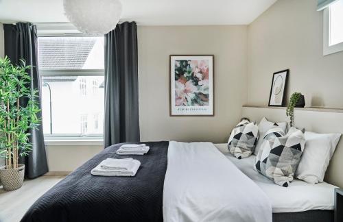 um quarto com uma cama grande e almofadas pretas e brancas em Hatty's Habitat By Staysville em Stavanger