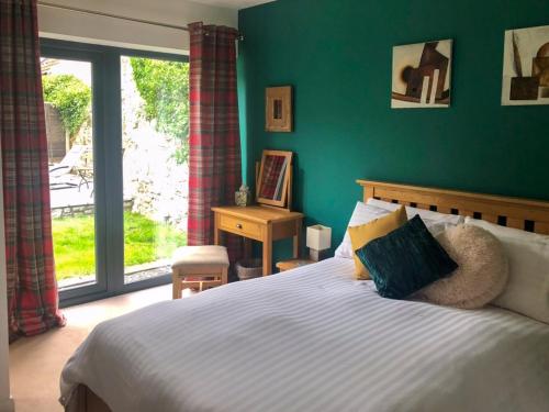 1 dormitorio con cama y pared verde en Townsend Pod en Greinton