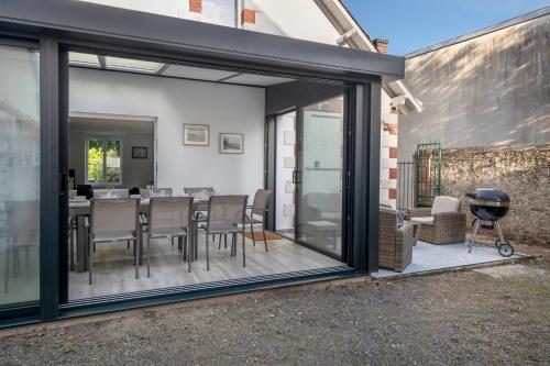 un patio avec une table, des chaises et un barbecue dans l'établissement À 50m de la plage, jolie maison pour 8, à Saint-Michel-Chef-Chef