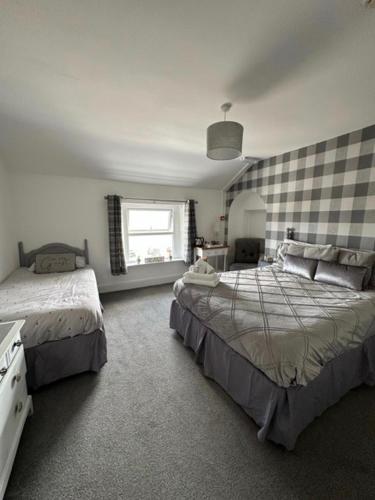 a bedroom with two beds and a window at The Beach House in Lowestoft