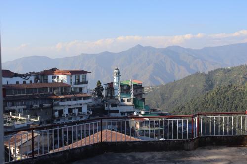 a view of a building with mountains in the background at Hotel Tourist Home By palak Hospitality in Mussoorie