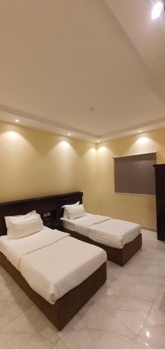 een kamer met drie bedden in een kamer bij درة الراشد للشقق المخدومة in Hafr Al Baten