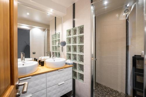 a bathroom with two sinks and a shower at 2-pièces ensoleillé, 5 min du metro in Villejuif