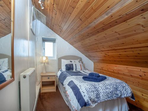 Bugle的住宿－Tanglewood，一间卧室设有一张床和木制天花板