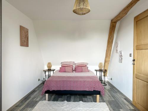 um quarto branco com uma cama com almofadas cor-de-rosa em Room in Guest room - bed and breakfast in the countryside near Beauvais airport em Auneuil