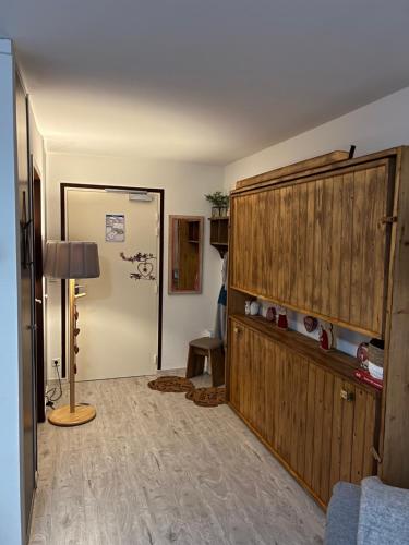 uma sala de estar com um grande armário de madeira e um candeeiro em Studio Croix du berger em La Feclaz