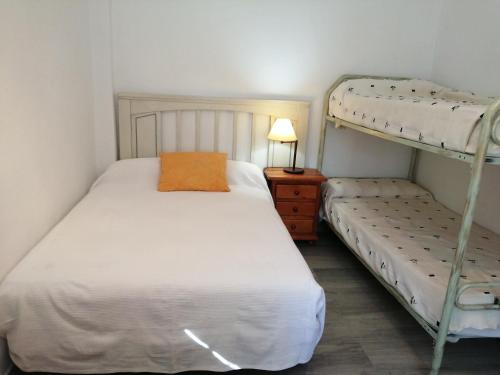 1 dormitorio con 2 literas y lámpara en La Morada del Yayo 15 minutos de Sevilla, en Las Pajanosas