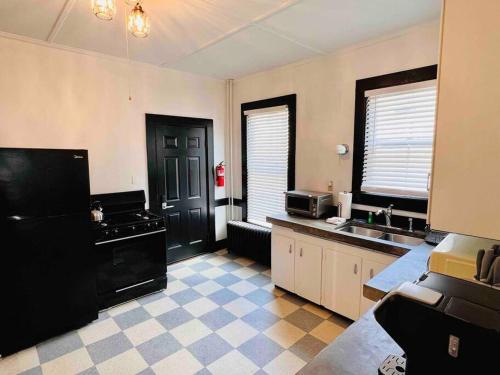 a kitchen with a black refrigerator and a sink at Centrally located East End & off-street parking in Portland