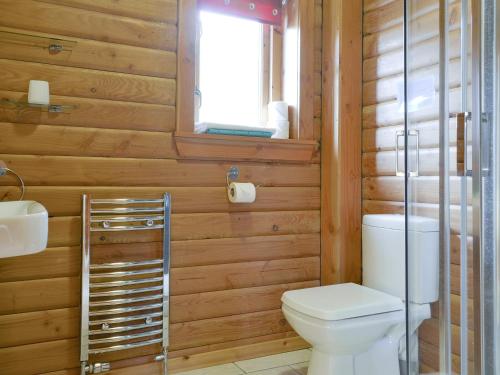 a bathroom with a toilet and a sink and a window at Seascape in Flodigarry