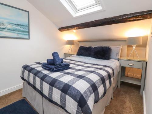 a bedroom with a bed with a checkered blanket on it at Royal Next View in Carnforth