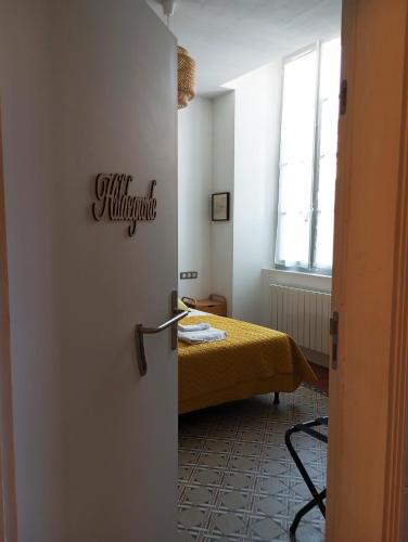 a room with a bed in a room with a door at Chambre d'hôtes PMR Hildegarde in Moissac