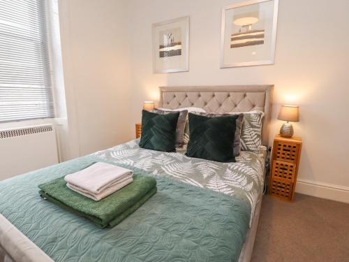 a bedroom with a bed with green sheets and pillows at Royal Barn View in Carnforth