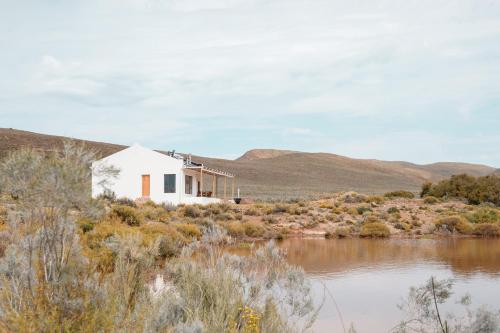 Biały dom na brzegu rzeki w obiekcie Drie Kuilen Nature Reserve w mieście Touwsrivier