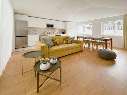 a living room with a yellow couch and a table at Vibrant Porto Apartments-Campo 24 Agosto in Porto