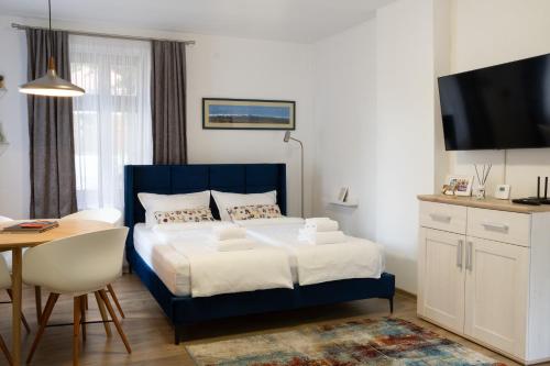 um quarto com uma cama azul, uma mesa e uma secretária em Transylvanian Valley em Sibiu