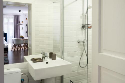 a white bathroom with a sink and a shower at Transylvanian Valley in Sibiu