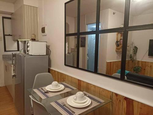 a room with a table and a mirror and a kitchen at Urban Chique Condo in Marilao Bulacan near PhilippineArena in Marilao