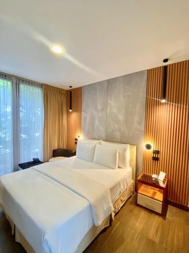 a bedroom with a large white bed and a window at Hotel La Isla in Puerto Ayora