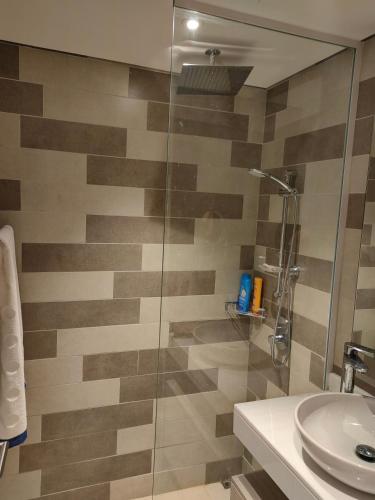 een badkamer met een glazen douche en een wastafel bij 7 Palm Jumeirah in Dubai