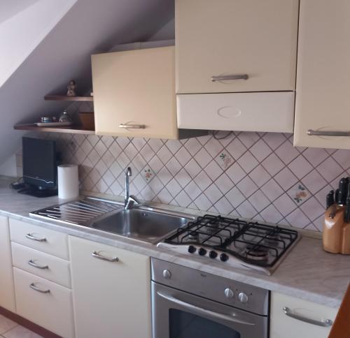eine Küche mit einer Spüle und einem Herd in der Unterkunft Romano's House in Castel di Lama
