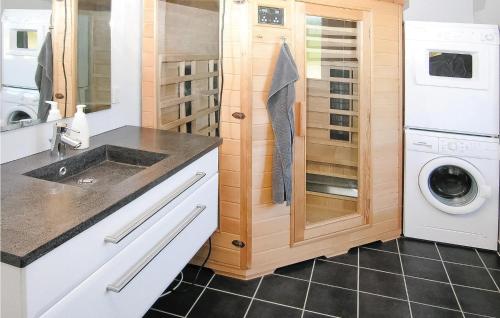 a kitchen with a washer and dryer next to a washing machine at Beautiful Home In Hemmet With 4 Bedrooms, Sauna And Wifi in Falen