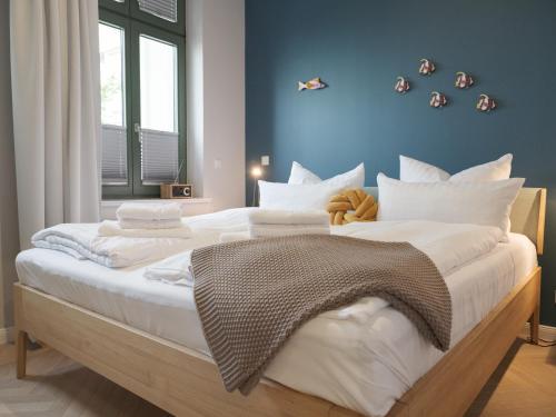 ein Schlafzimmer mit einem großen Bett mit weißen Kissen in der Unterkunft OSTKÜSTE - Villa Steigel Design Apartments in Ahlbeck