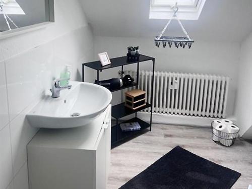 a white bathroom with a sink and a radiator at Comfy Apartment in Krefeld in Krefeld