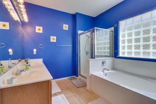 Baño azul con bañera y lavamanos en Spacious Hutto Retreat with Large Private Backyard, en Hutto
