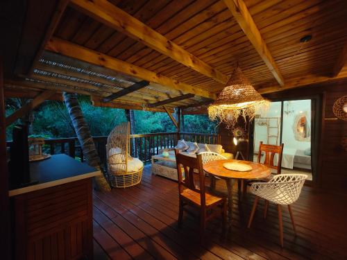 a wooden deck with a table and chairs at OHANA Jungle Lodges in Les Avirons