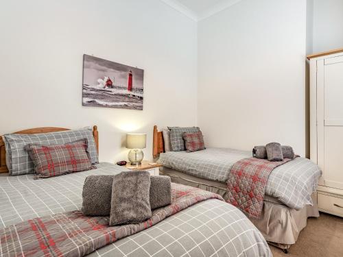 a bedroom with two beds and a table at Admirals Rest in Cromer