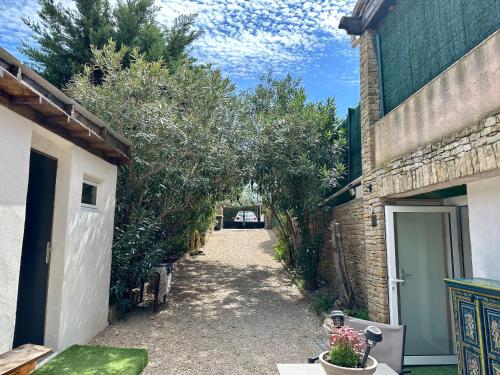 um beco entre dois edifícios com árvores e uma entrada em STUDIO BIBOUNE em Ceyreste