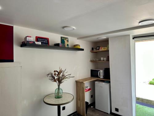 een keuken met een kleine tafel en een koelkast bij STUDIO BIBOUNE in Ceyreste