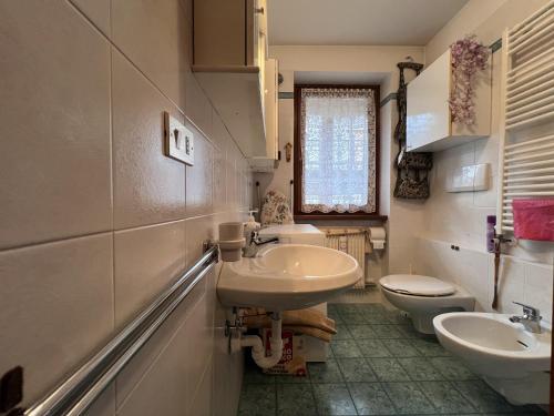 a bathroom with two sinks and two toilets at 060 Bilocale, Giustino in Giustino