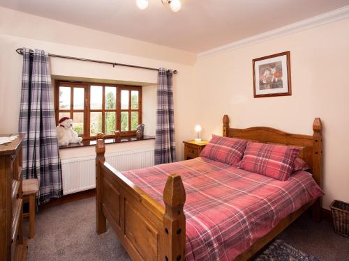 a bedroom with a bed and a window at Craigellachie Cottage in Croy