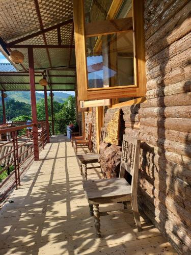 a row of benches on the porch of a building at Moc's House bắc hà in Bắc Hà