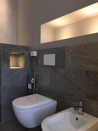 a bathroom with a white toilet and a sink at Studio - Villa Cardano in Como