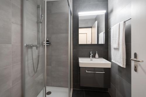 ein Bad mit einem Waschbecken und einer Dusche in der Unterkunft Studio RAFAEL Interlaken in Interlaken