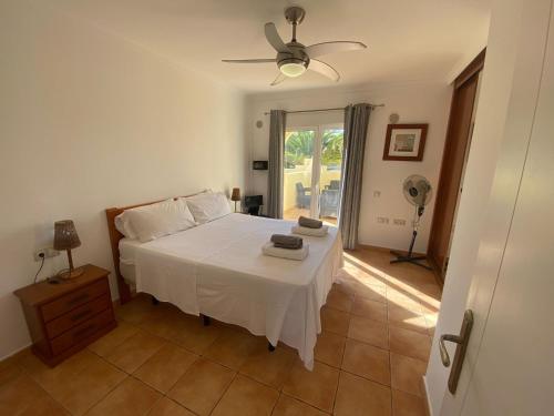 a bedroom with a white bed and a fan at 60 El Sultan, 20 Pedroy Guy Vandaele in Corralejo