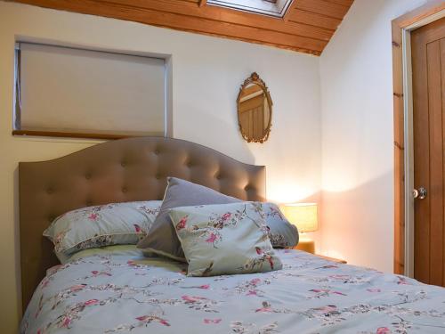 um quarto com uma cama com almofadas em Ukc4173 The Cottage By The Sea Annexe em Littlehampton