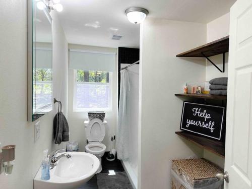 Baño blanco con lavabo y aseo en The Good Neighbors Home, en Conway