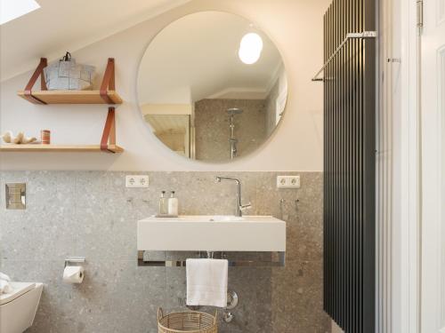 a bathroom with a sink and a mirror at OSTKÜSTE - Villa Steigel Design Apartments in Ahlbeck